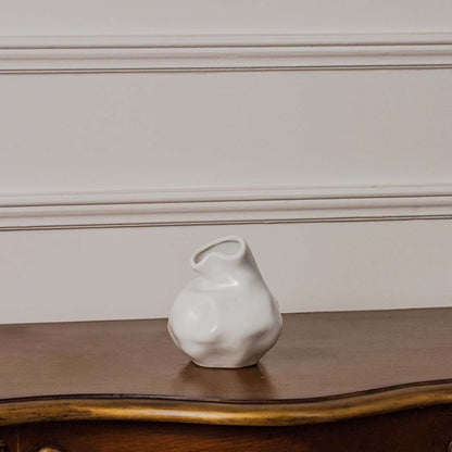 White ceramic vase with wavy neck and glossy finish displayed on white background perfect for floral arrangements.