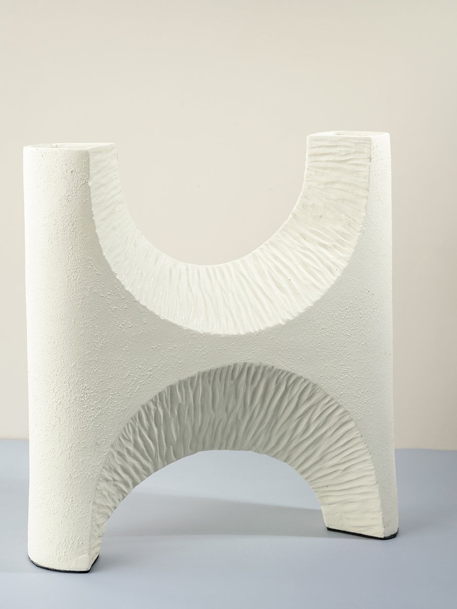 Contemporary white ceramic vase with artistic cutout texture stylish accent piece for interior decoration.