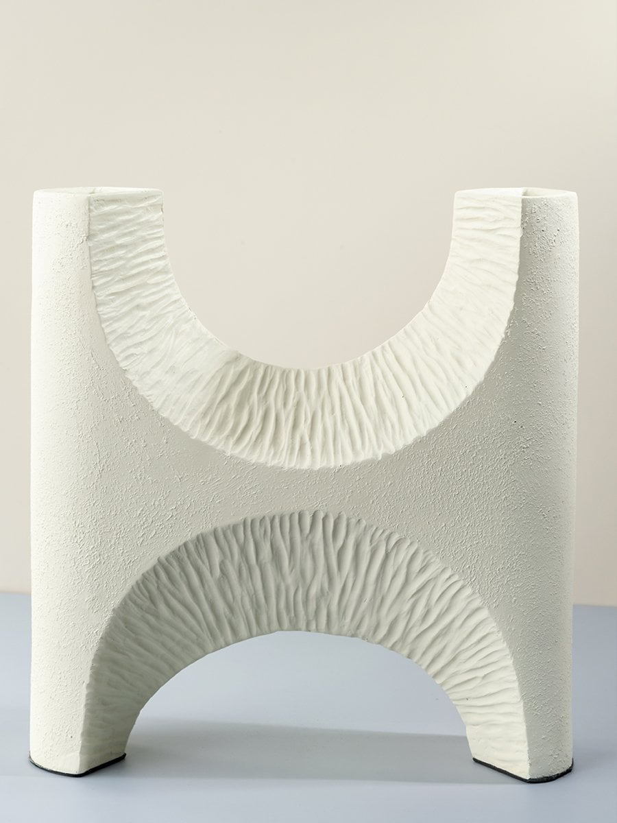 White ceramic sculptural vase with textured cutout design modern decorative accent for home and office decor.