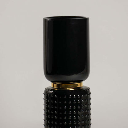 Closeup of black and gold ceramic vase showing textured detailing and glossy finish ideal for modern luxurious home styling.