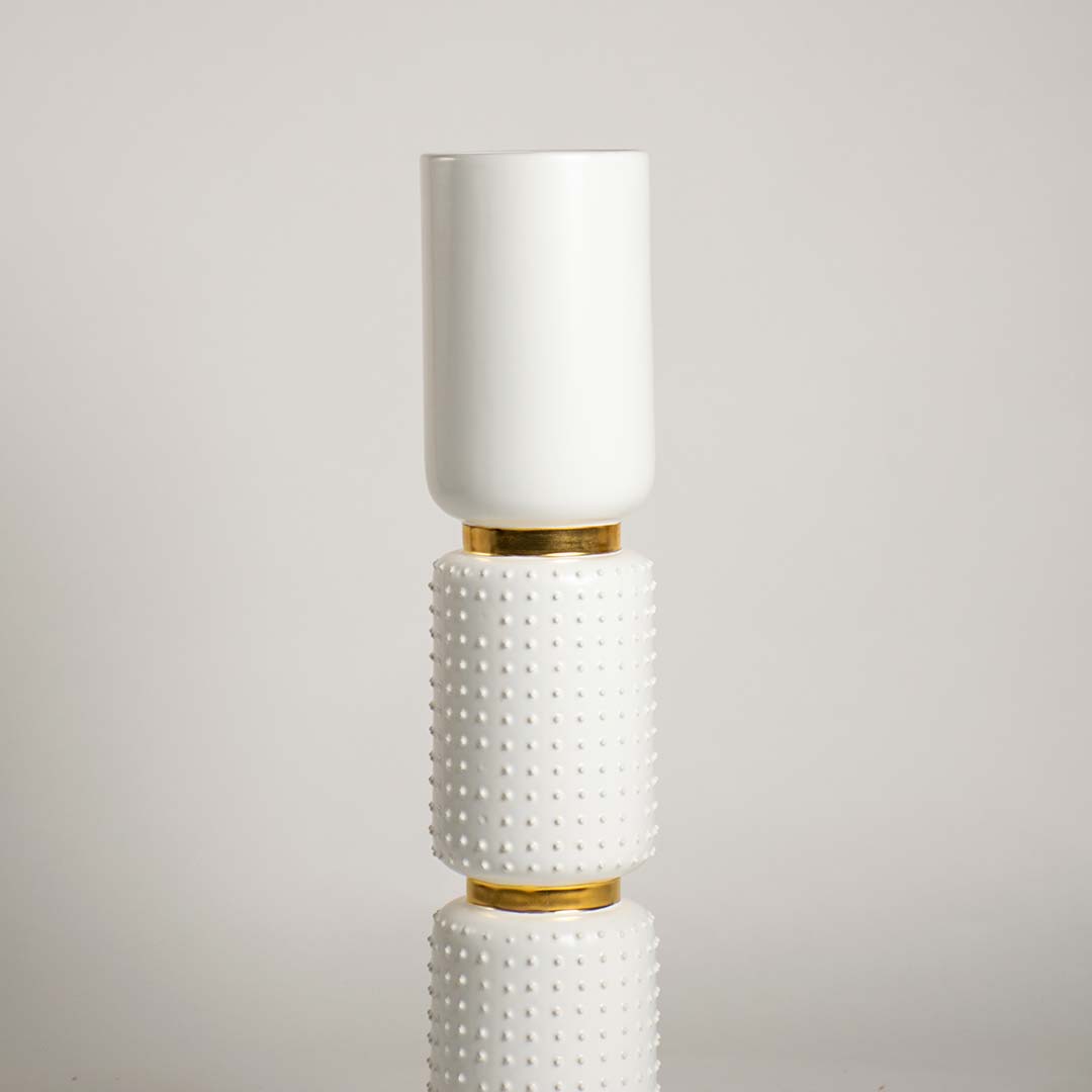 Closeup of the white and gold vase featuring detailed ceramic texture raised bumps and smooth top vessel showcasing its refined handcrafted finish.