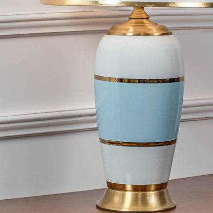 Close up table lamp base with white and blue ceramic finish and gold accents modern classic decorative lighting for home interiors.