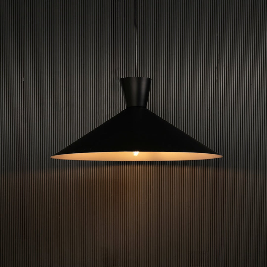 Black cone pendant light against dark panel wall with light on for stylish contemporary décor.