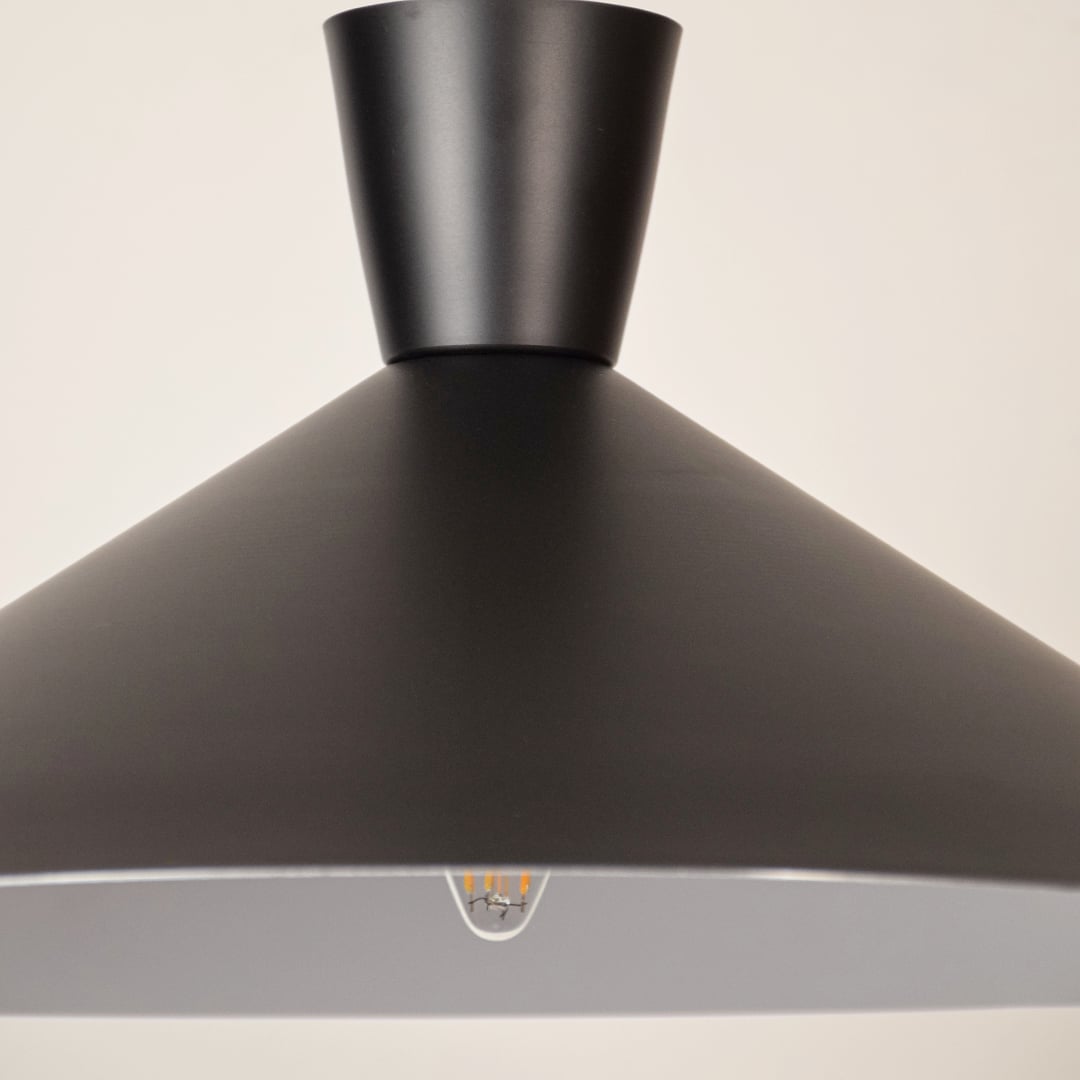 Black metal pendant light closeup highlighting refined craftsmanship and premium modern lighting design details.