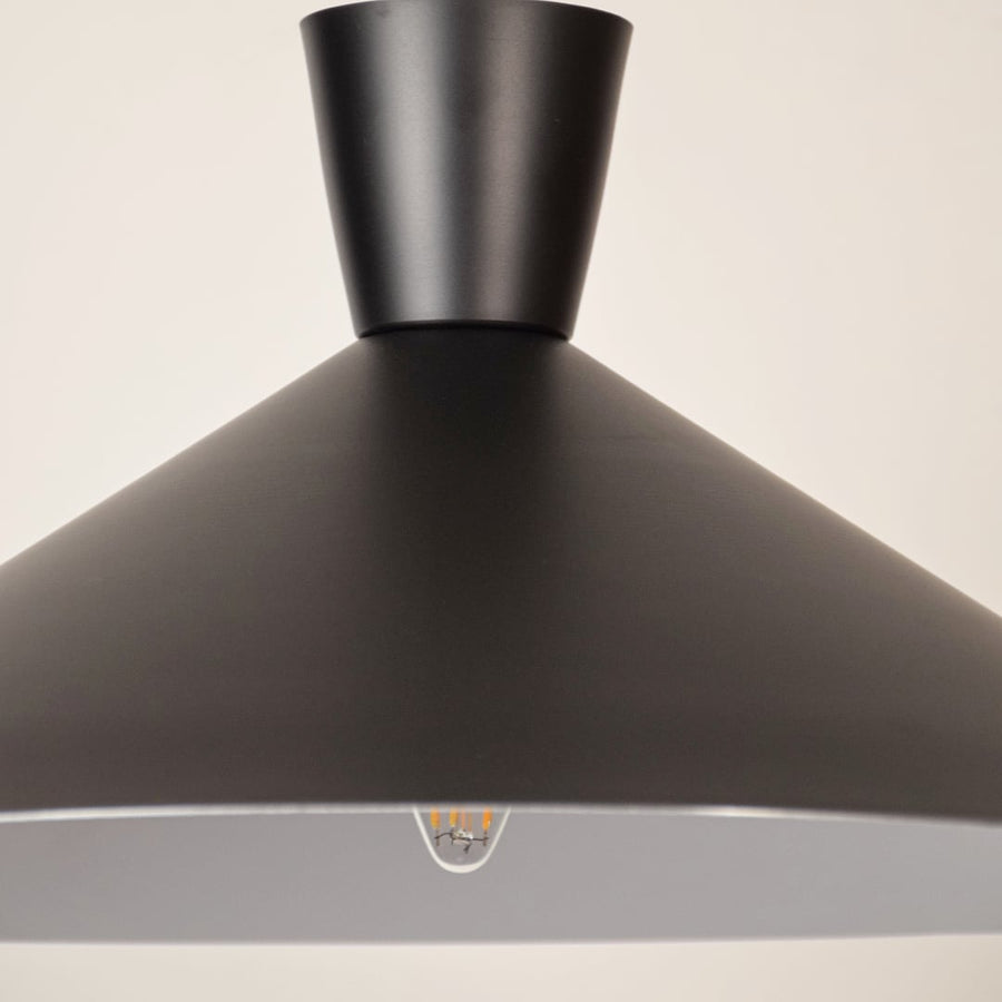 Black metal pendant light closeup highlighting refined craftsmanship and premium modern lighting design details.