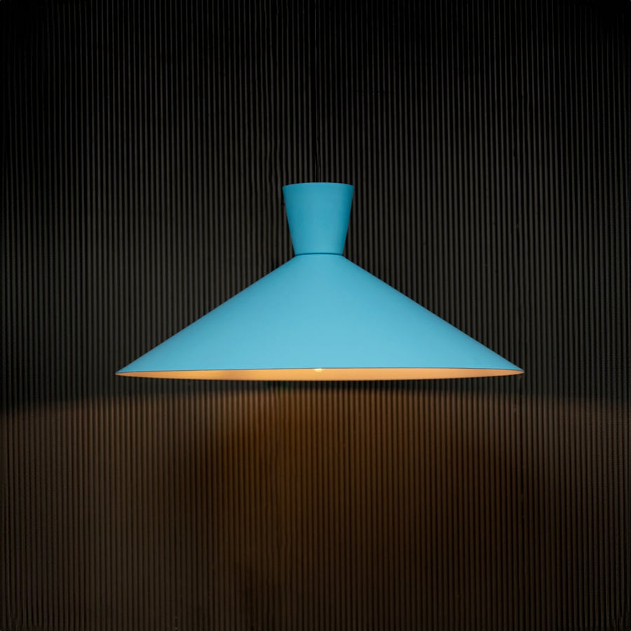 Modern blue metal pendant light turned on with a wide cone shaped shade casting a warm downward glow ideal for contemporary home décor.