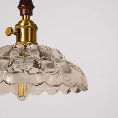 Closeup of textured clear glass and brass metal pendant light showcasing premium detailing.