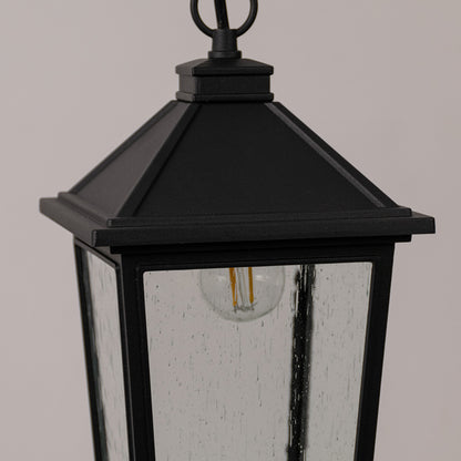 Closeup outdoor lantern in black metal finish with glass panels and top detail for entrance or garden decor lighting white background.