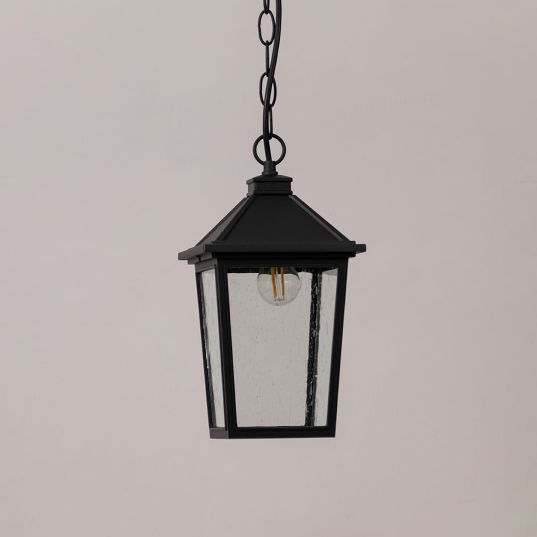 Black outdoor lantern with the light switched off shown on a white background featuring textured glass and a sleek square frame.
