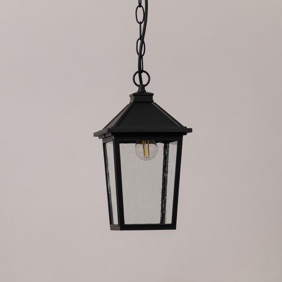 Black outdoor lantern with the light switched off shown on a white background featuring textured glass and a sleek square frame.