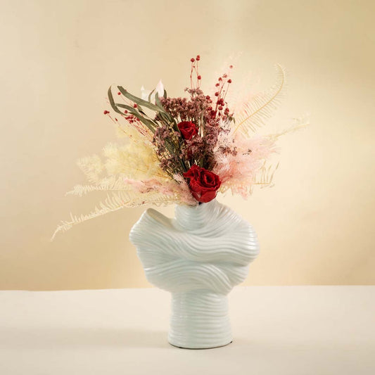 Textured white ceramic vase styled on neutral background casting soft shadows for artistic home interior decor.