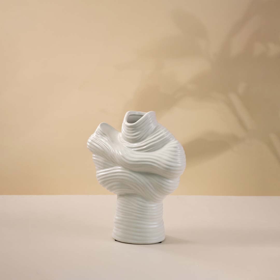 Modern white ceramic vase with sculptural folds and smooth matte finish shown on white background for decor accent.