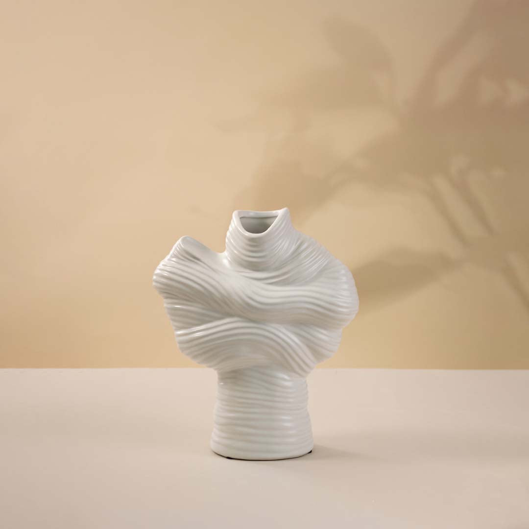 White ceramic decorative vase with sculptural twisted top design for elegant tabletop styling and modern home decor.