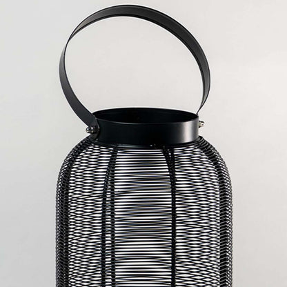 Closeup of black metal mesh lantern with curved handle for luxury tabletop decor styling use.