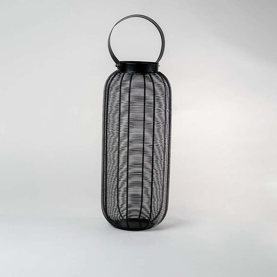 Unlit tall black wire mesh lantern isolated on white background featuring sleek cylindrical shape and sturdy handle for modern styling.