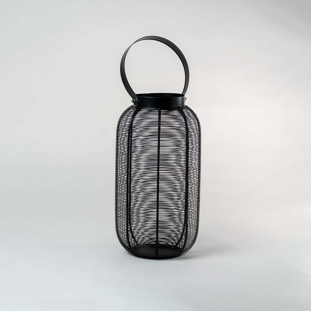 Unlit black wire mesh lantern isolated on white background featuring sleek cylindrical shape and sturdy handle for modern decor.