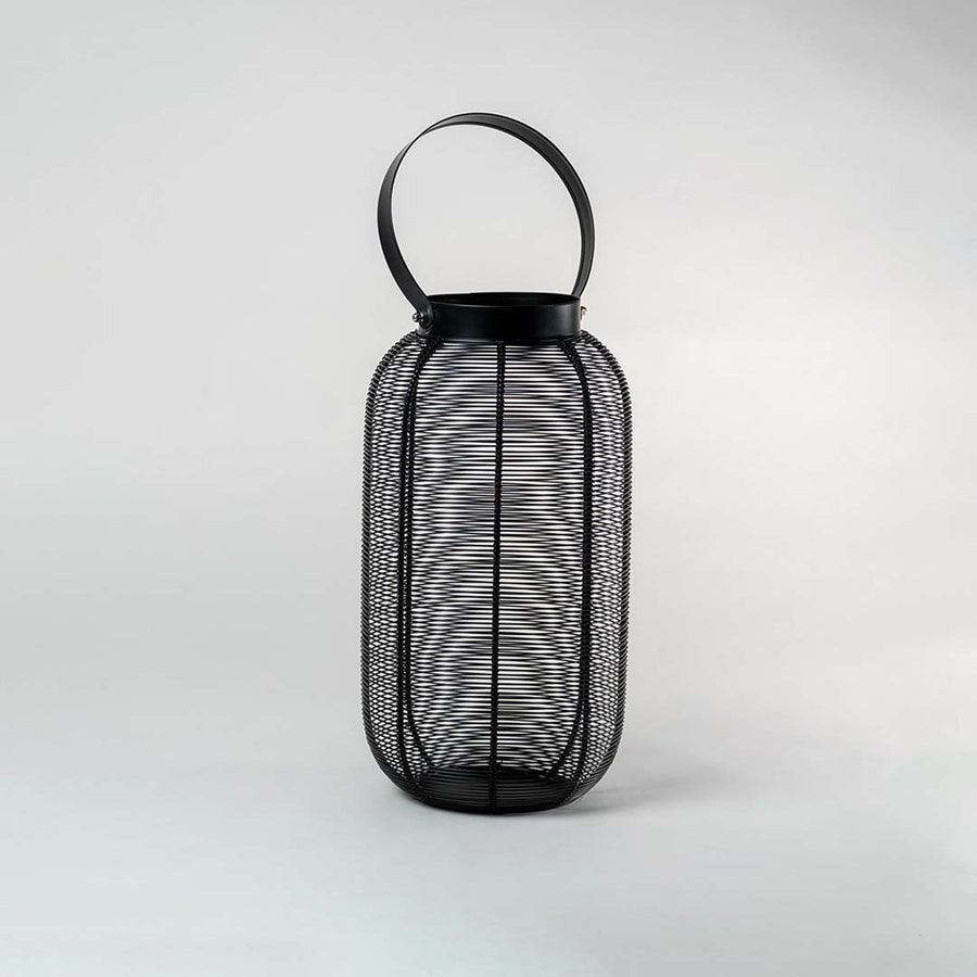 Unlit black wire mesh lantern isolated on white background featuring sleek cylindrical shape and sturdy handle for modern decor.