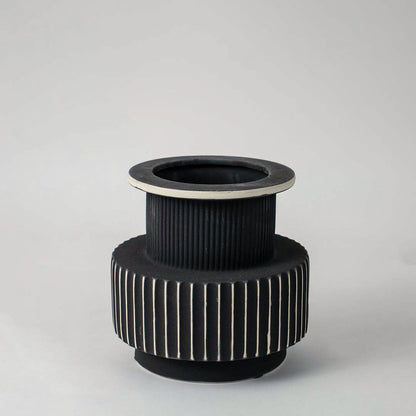 Stylish black and white ceramic vase with detailed ribbed texture shown on plain white background for interior decoration.