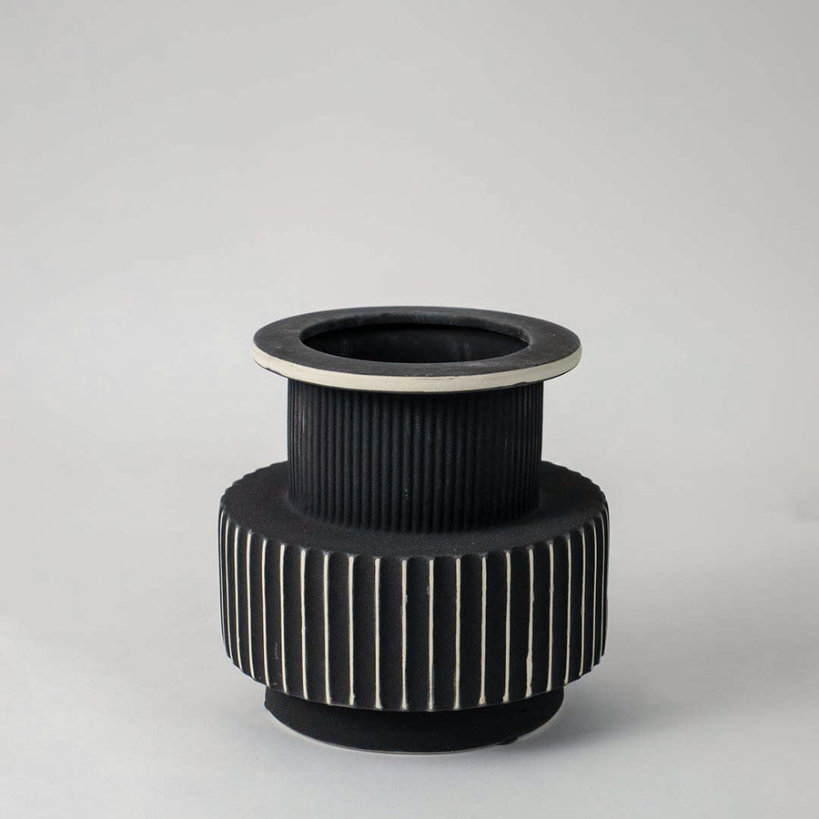 Stylish black and white ceramic vase with detailed ribbed texture shown on plain white background for interior decoration.