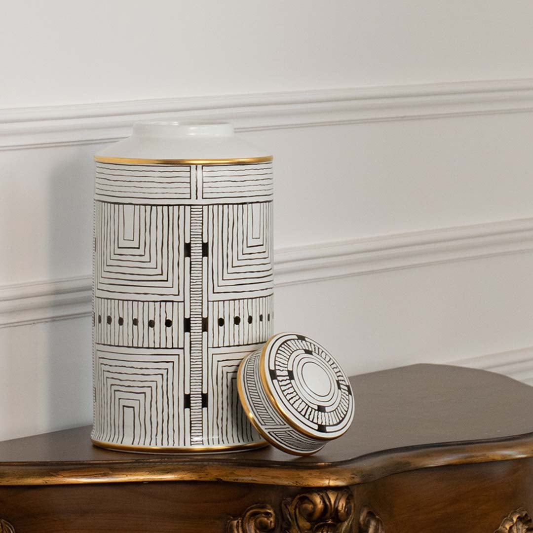 White ceramic jar with black geometric line pattern shown on simple backdrop for modern minimalist décor.
