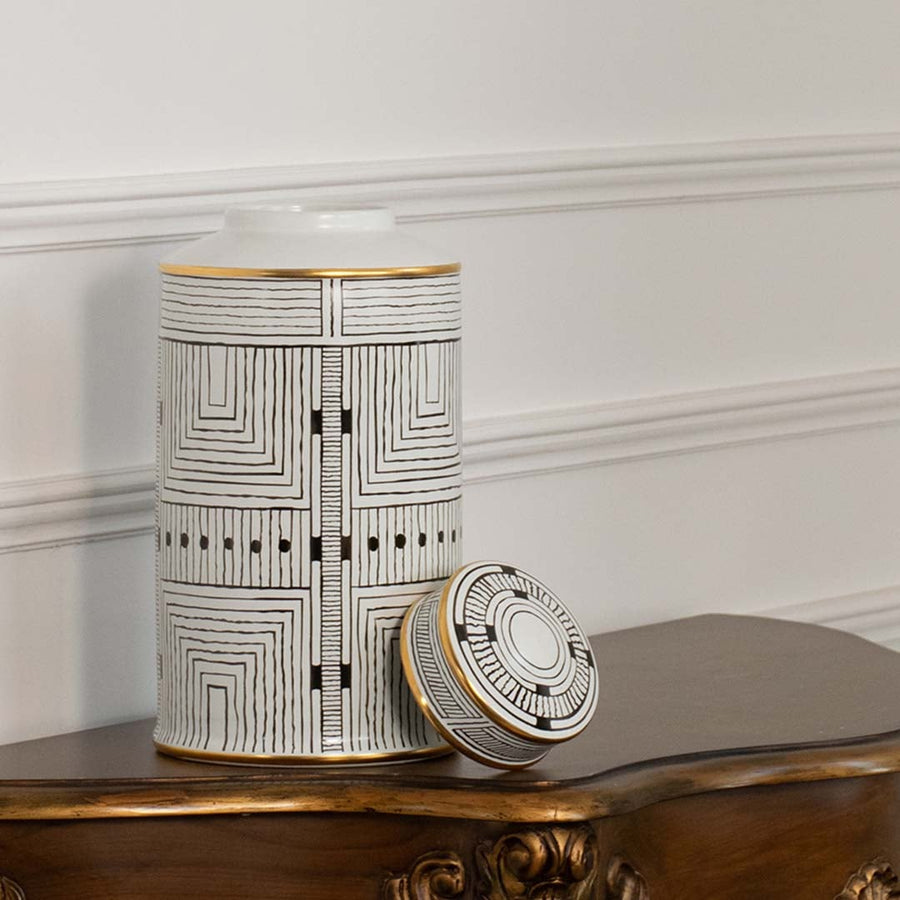 White ceramic jar with black geometric line pattern shown on simple backdrop for modern minimalist décor.