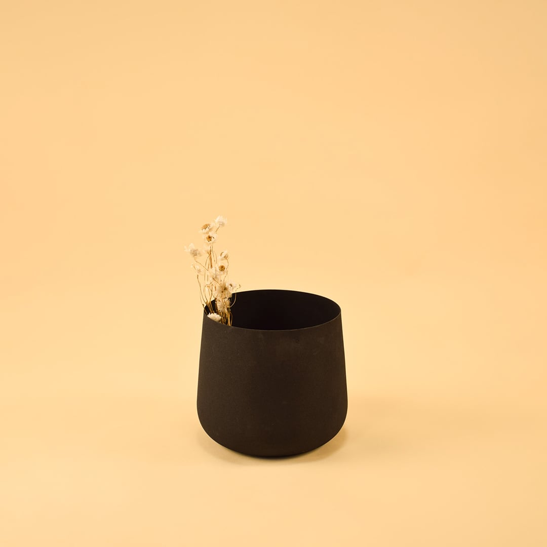 Modern black metal planter placed in a warm neutral layout adding depth and minimal charm to home styling.