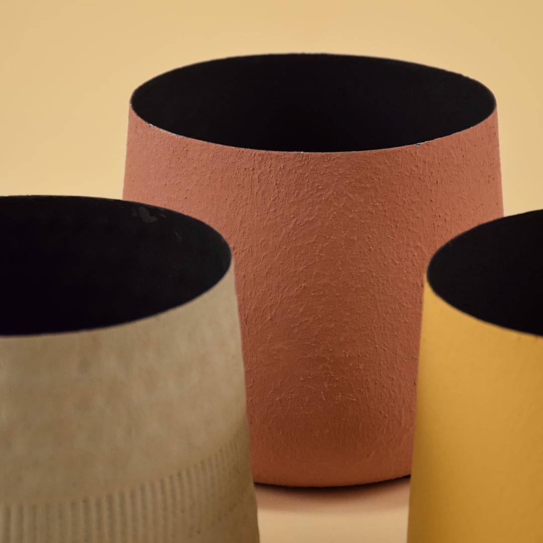 Closeup of black metal planter showing matte textured finish and rounded shape for a bold modern decor accent.