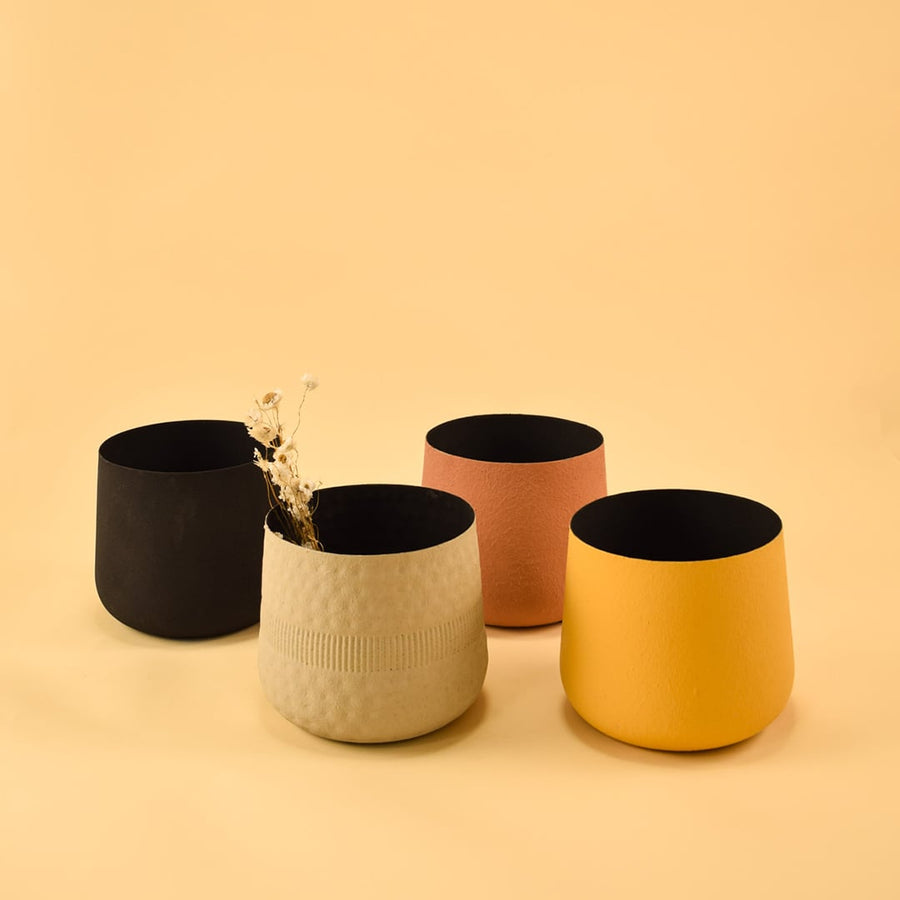 Black textured metal planter grouped with decor pieces creating a sleek cohesive look for shelves and tabletop styling.
