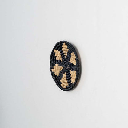 Round jute and black woven wall basket decor handmade rustic boho star design wall art accent piece shown from side view.