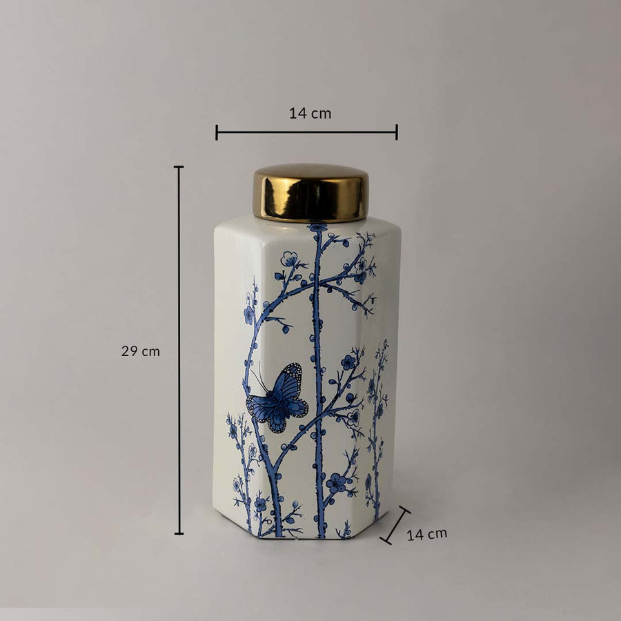 Blue and white ceramic jar with butterfly pattern and golden lid shown with 29 cm height and 14 cm width dimension.