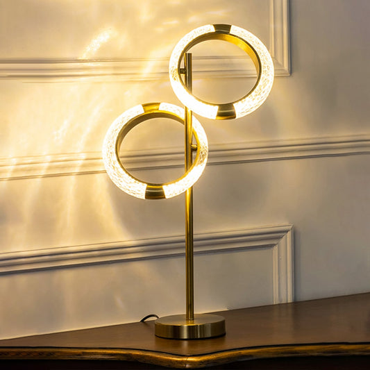 Crystal ring table lamp with gold base turned on against white background perfect for luxury bedside decor table lamp.