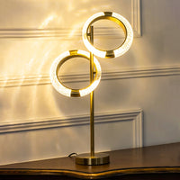Crystal ring table lamp with gold base turned on against white background perfect for luxury bedside decor table lamp.