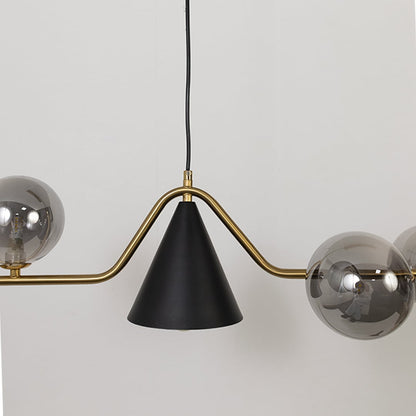 Closeup view of the chandelier showcasing its metallic globes curved golden bar and matte black cone detail with refined craftsmanship.