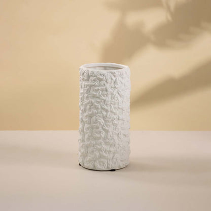 Contemporary white textured ceramic vase with matte finish highlighted against a white background for contrast.