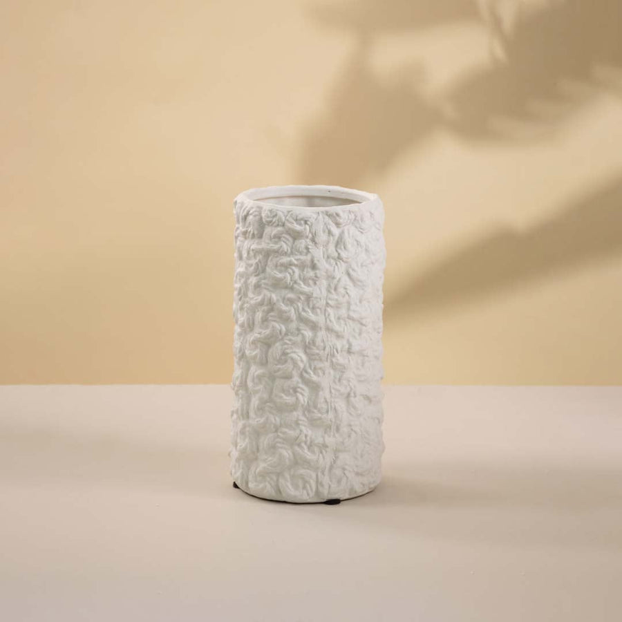 Contemporary white textured ceramic vase with matte finish highlighted against a white background for contrast.