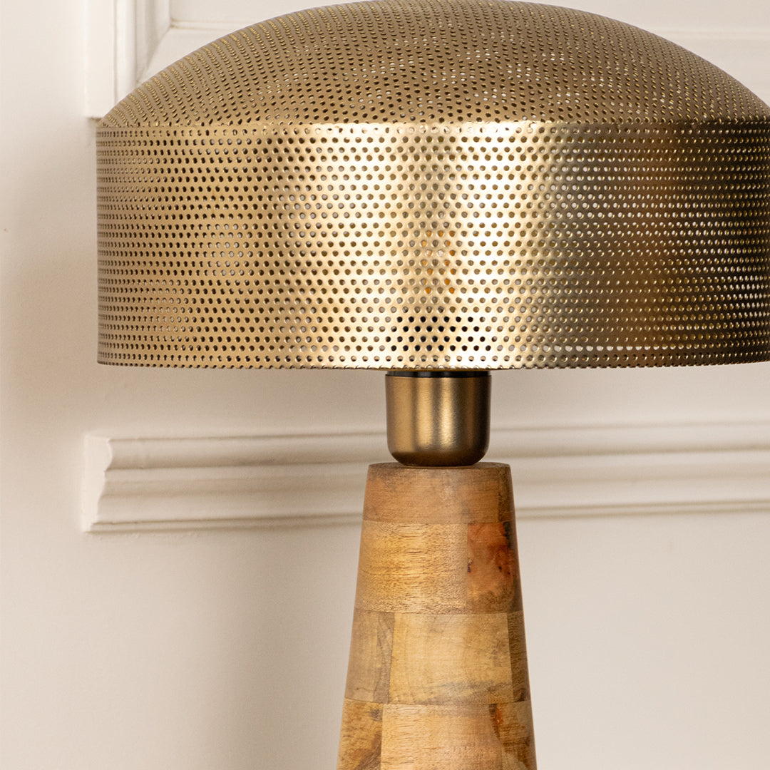 Closeup of gold metal table lamp with textured shade for elegant bedroom and living room decor styling.