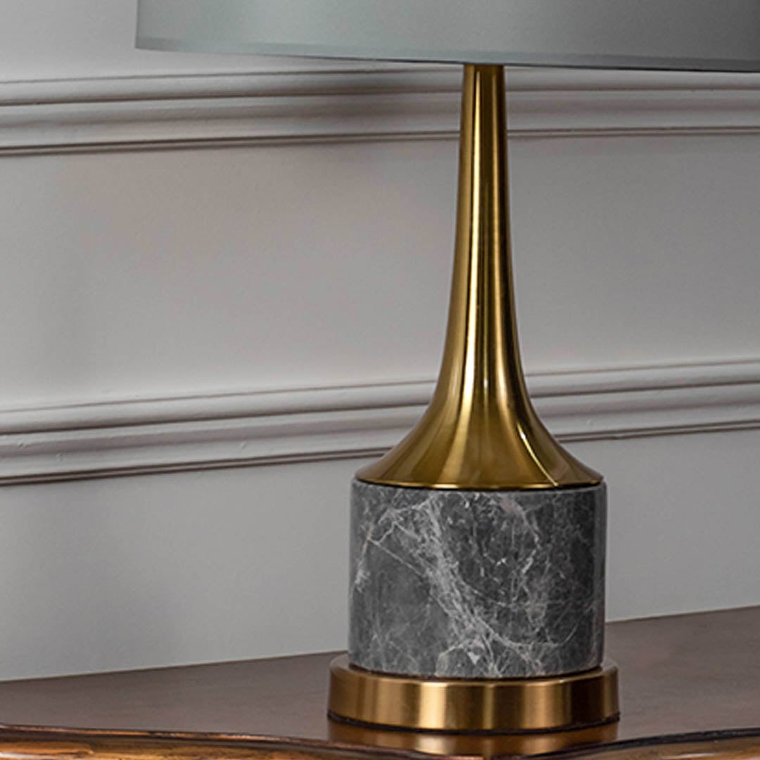 Grey marble base gold neck table lamp shown in close up view with light off for modern luxury décor styling.