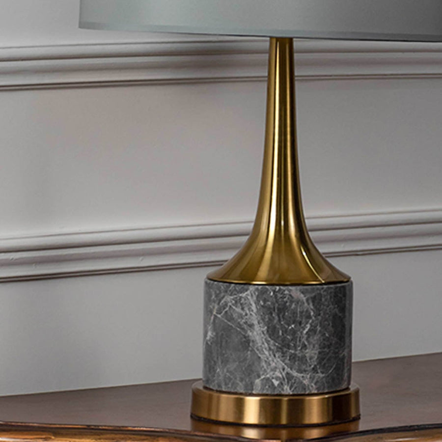 Grey marble base gold neck table lamp shown in close up view with light off for modern luxury décor styling.