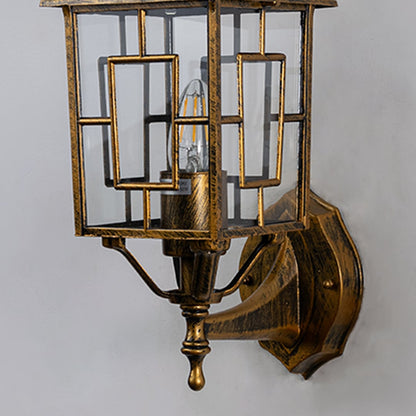 Closeup of vintage style wall light with gold metal frame and glass panels highlighting ornate detailing and luxury craftsmanship.