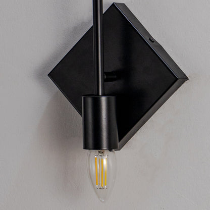 Minimal wall light with black diamond plate and exposed filament bulb on neutral background industrial style lighting for home decor.