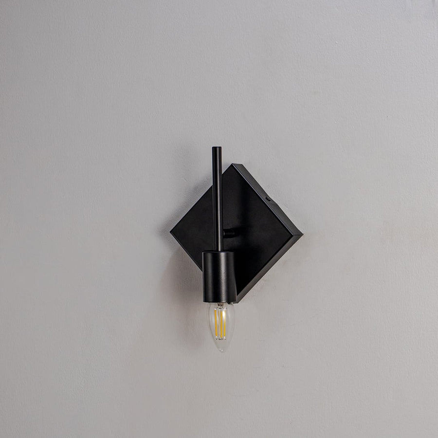 Light Off White Background Image Modern wall light with matte black circular frame and gold bulb holder shown off on white background for stylish interiors.