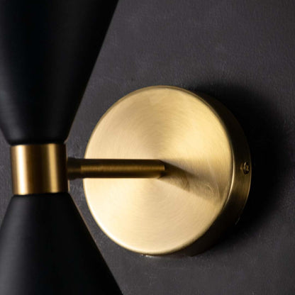 Detailed closeup of the black and gold double shade wall light highlighting the matte texture smooth edges and refined gold accents of the modern fixture.