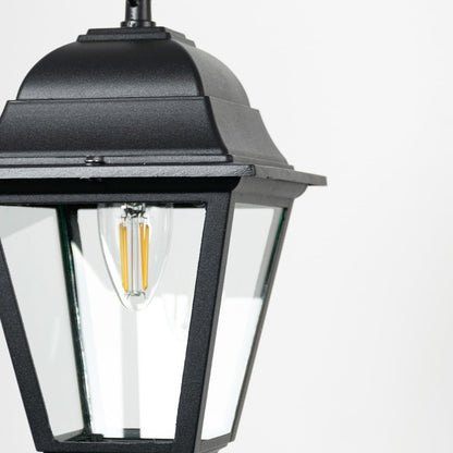 Closeup of outdoor hanging lantern light showing bulb detail and refined black metal finish.
