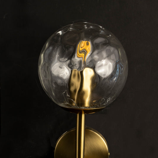 Closeup of smoked glass globe light bulb with warm LED filament for modern decorative lighting display.