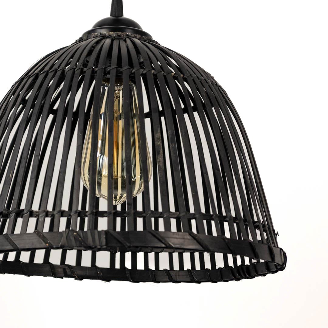 Closeup of black rattan hanging lamp showing handcrafted weaving pattern and warm glowing filament bulb.