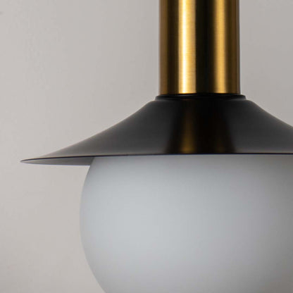 Closeup white globe pendant light with gold metal shade placed against neutral wall background highlighting premium modern lighting craftsmanship.
