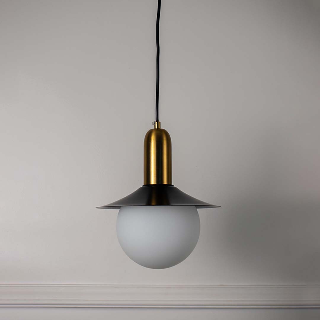 White glass pendant light with black metal shade and brass accents crafted for modern interiors.