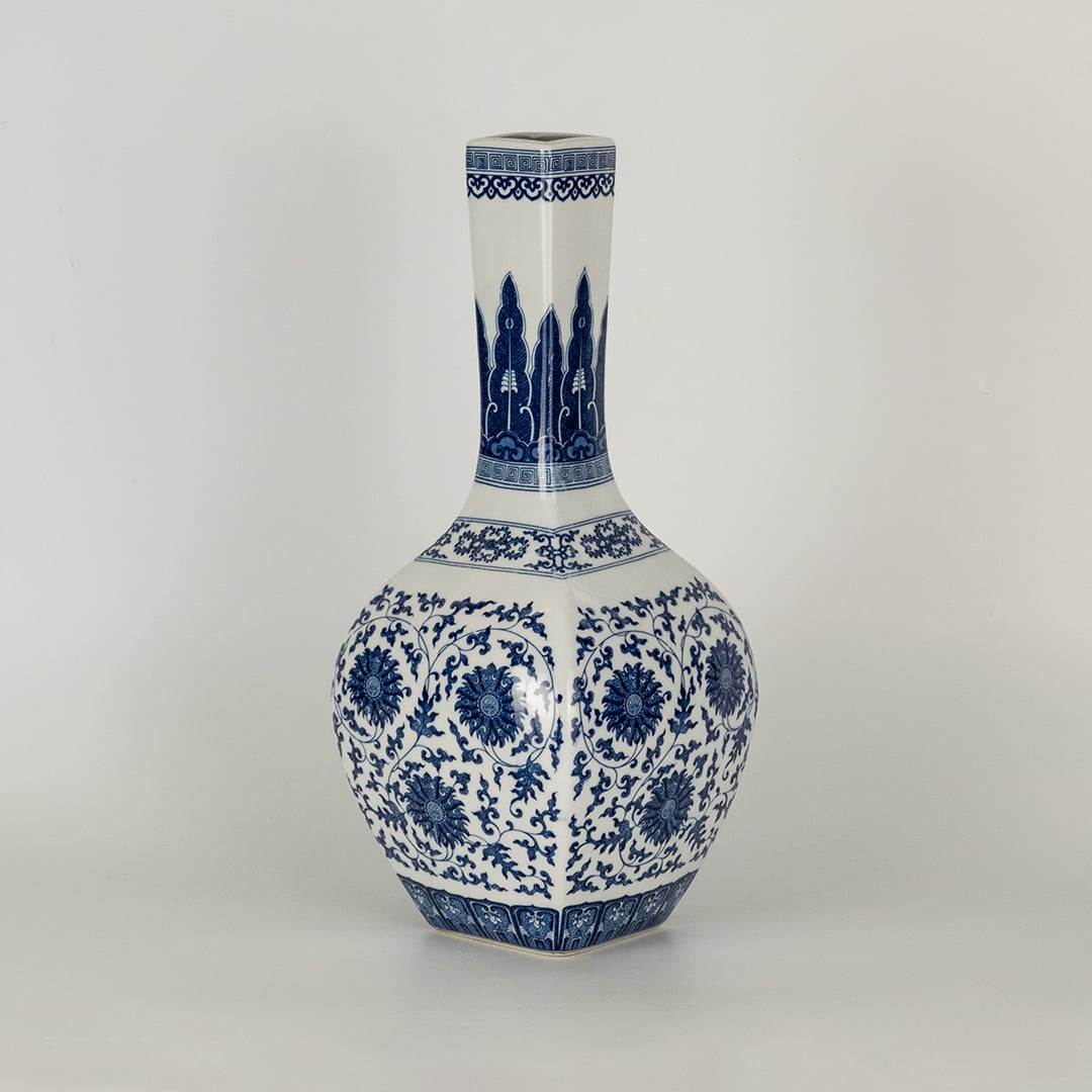 Blue and white ceramic jar with a tall narrow neck covered in intricate floral patterns presented in a studio setting creating a classic artistic presence suited for elegant decor.