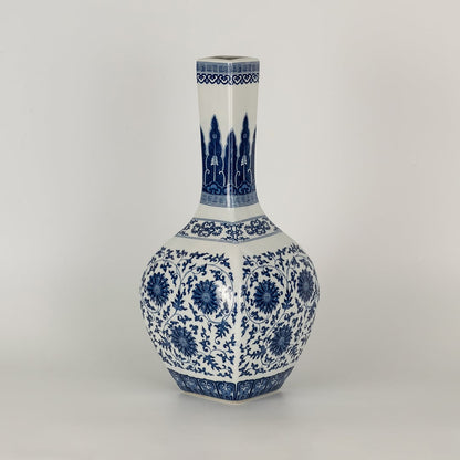 Blue and white ceramic jar with a tall narrow neck covered in intricate floral patterns presented in a studio setting creating a classic artistic presence suited for elegant decor.