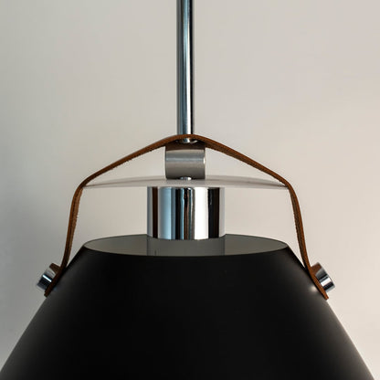 Closeup of black pendant light showing premium matte finish and tan leather strap connecting the metal frame.